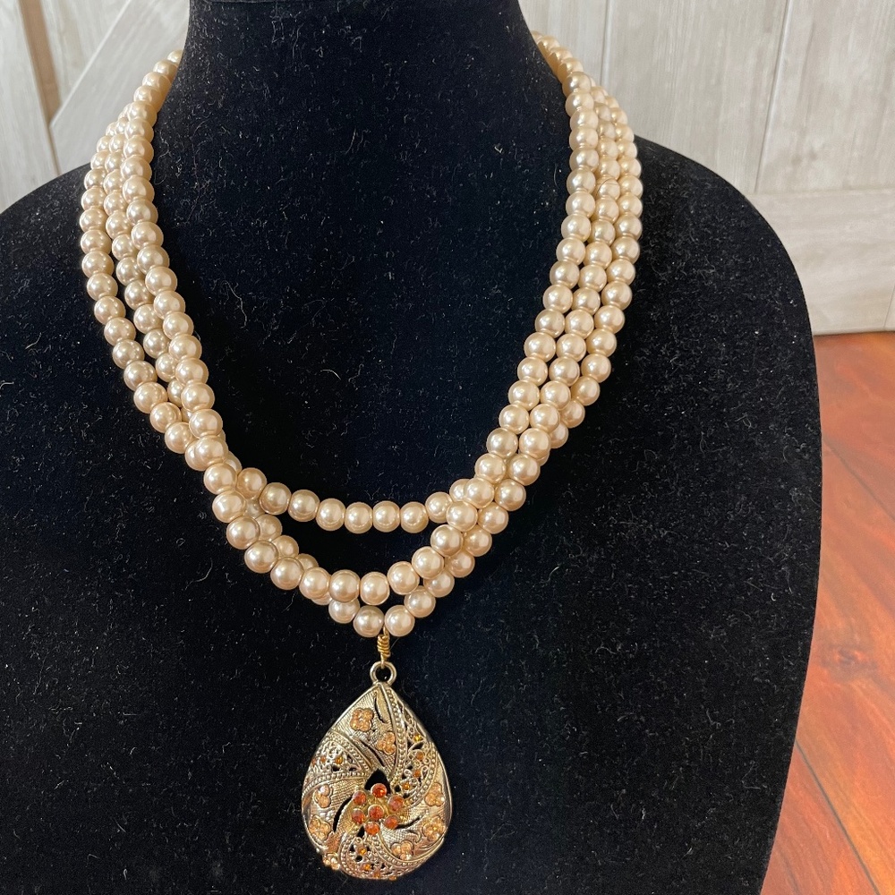 Multi strand pearl necklace with drop centerpiece